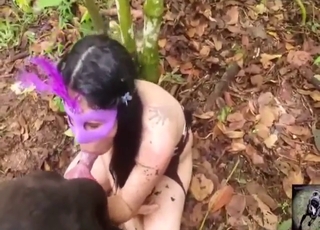 Brunette with a pretty mask sucking dog dick
